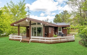 Enjoy the serene surroundings from the spacious deck area, featuring a large sliding glass door and outdoor seating.