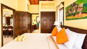 Een hotelkamer met een bed, houten deuren, een zithoek en een muurschildering.