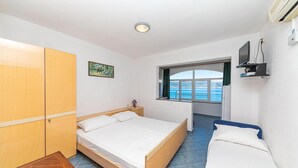 Una camera da letto con un letto, un armadio, una finestra vista e una TV montata a parete.