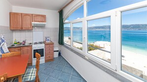 Una cucina con vista sul mare, un tavolo da pranzo e una sedia.