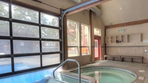 An indoor swimming pool with clear glass walls, benches, and an exit sign. - Cozy Ski-In / Walk-Out @ 4 O'Clock Lodge (Breckenridge)