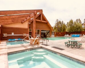 A wooden building with a pool area, including a hot tub, lounge chairs, and a table. - Cozy Ski-In / Walk-Out @ 4 O'Clock Lodge (Breckenridge)