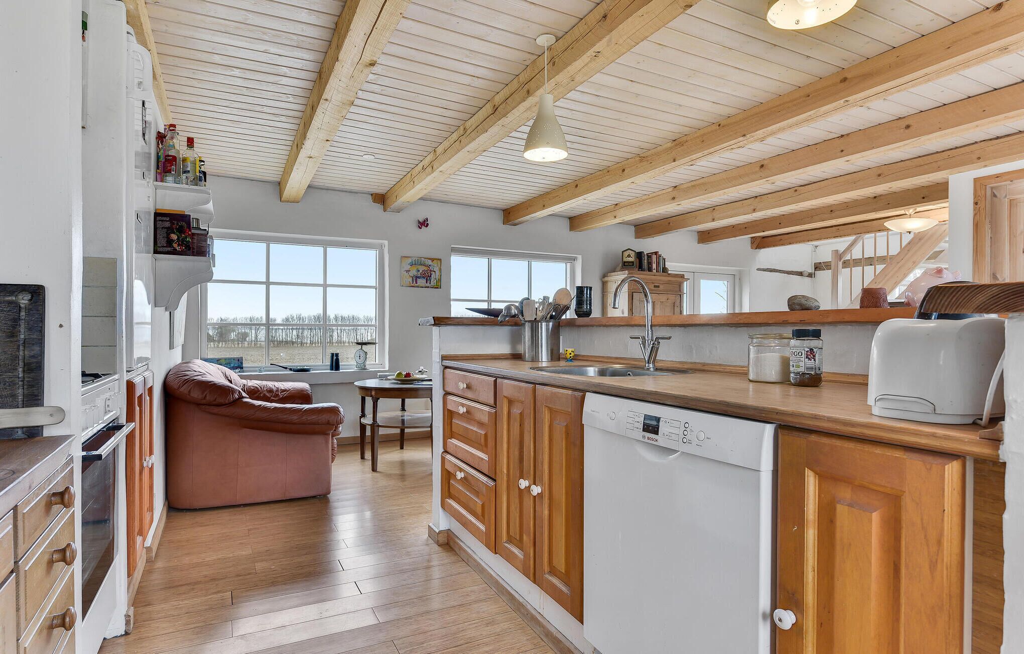 Una cucina moderna con mobili in legno, lavastoviglie e un'ampia finestra con vista sull'esterno.