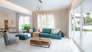 Una sala de estar moderna con un sofá modular, una mesa de centro y un comedor con mesa y sillas.