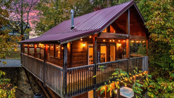 A wooden cabin with a balcony, a hot tub, and string lights. - Free Dollywood Tix+MtnViews+Pool+Couples+DogsOK (Sevierville)