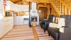 Ein Holzblockhaus-Interieur mit Küche, Essbereich und Kamin.