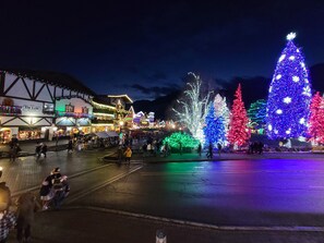 Een sfeervol marktplein buiten, met verlichte kerstbomen en gebouwen.