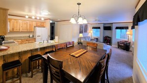 A spacious kitchen with granite countertops, wooden cabinets, and a central island with seating. - The Perfect Place (Leavenworth)