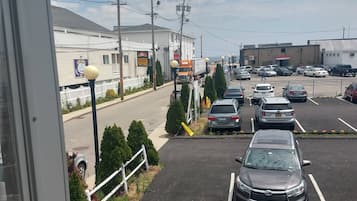 A parking lot with several cars, a building with a sign for 'Shops Inn', and a large truck.