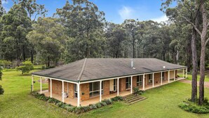 A two-story brick building with a tiled roof, surrounded by a well-maintained lawn and trees. - Bundara- Hunter Valley Retreat | Sleeps 11 | Rural | Resting amongst the trees (Congewai)
