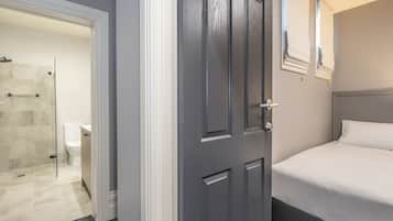 Une chambre à coucher avec un lit, une porte et un espace douche.
