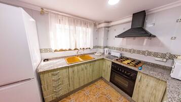 Een magnetron, een oven, een broodrooster, kookgerei, borden en bestek