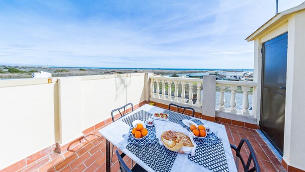 A terrace with a table set for breakfast, overlooking a coastal view. - Bonita casa en El Perellonet Valencia (Valencia El Perellonet)