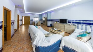 A spacious living area with a sofa set, a TV, and a dining table. - Bonita casa en El Perellonet Valencia (Valencia El Perellonet)