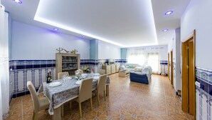 A spacious living room with a dining area, a sofa, and a TV. - Bonita casa en El Perellonet Valencia (Valencia El Perellonet)