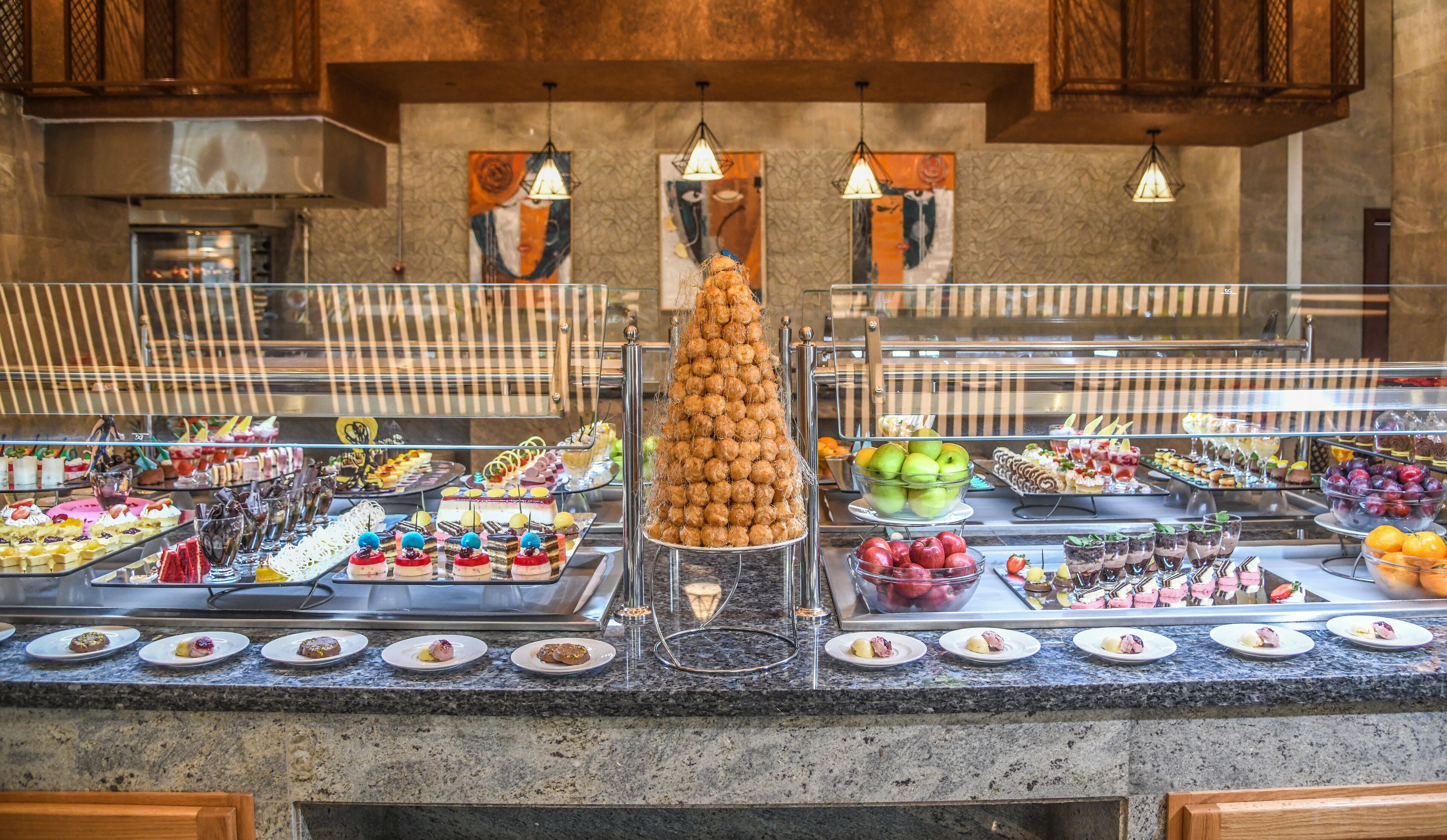 Un bufé con diversos alimentos y una presentación central de dulces esféricos.