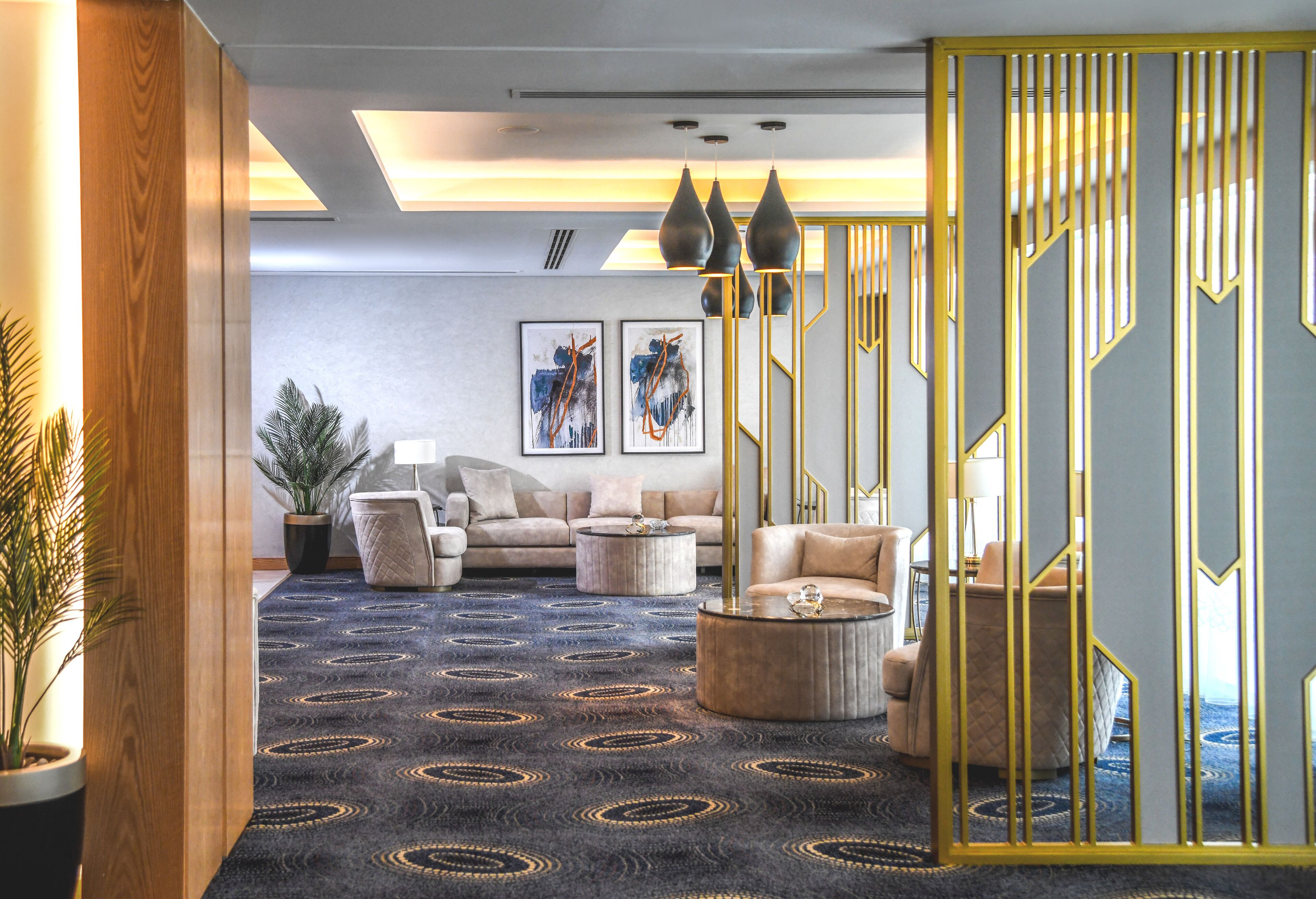 Una sala de estar moderna con alfombra estampada, un conjunto de sofá, una mesa de centro y una barandilla decorativa.
