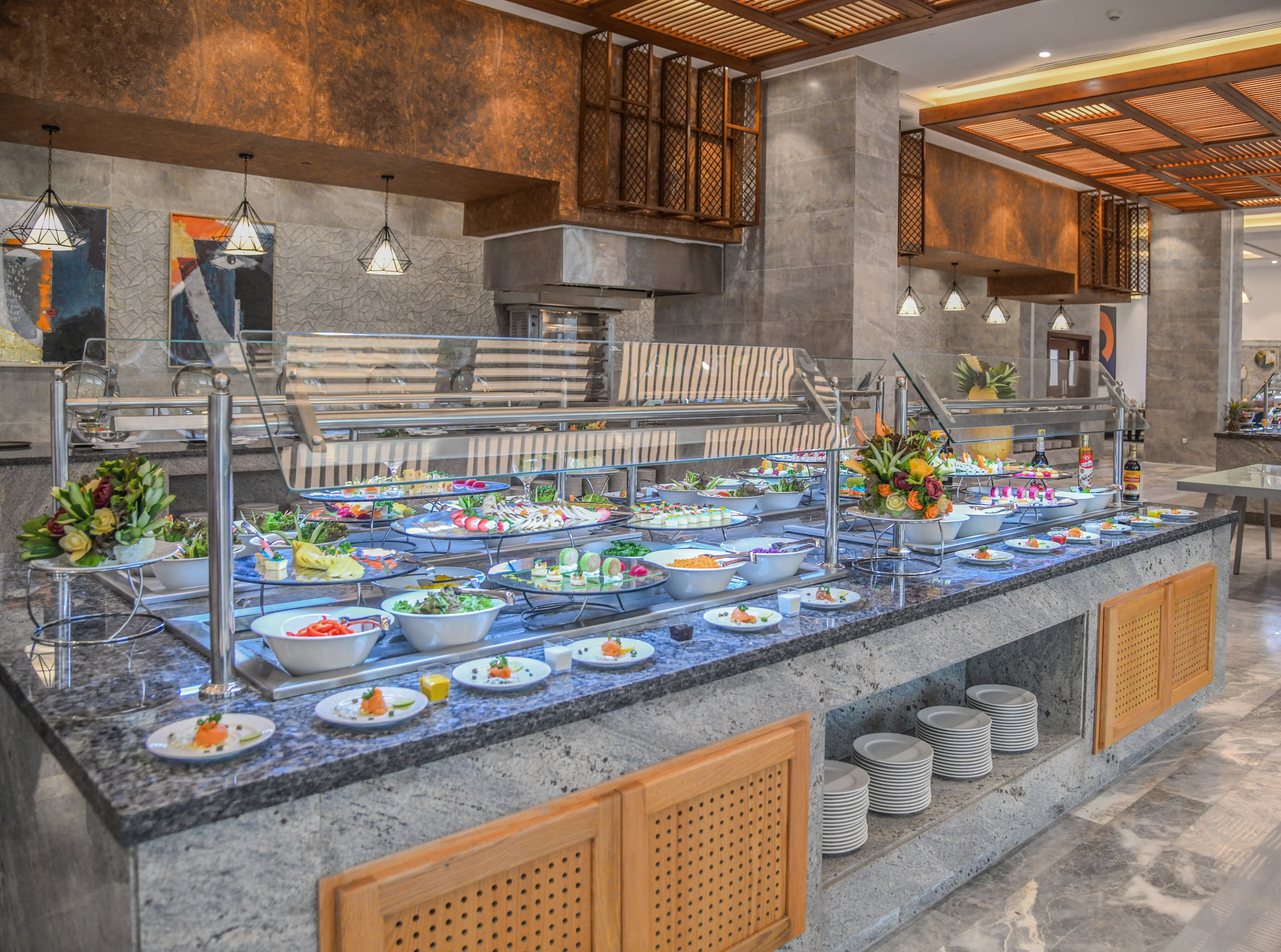 A buffet setup with various food items and a seating area with a wooden bench.