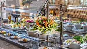 A buffet with various dishes and a decorative wall with a framed artwork. - Tolip Resort Elgalala Hills (Ataqah)