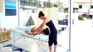 A massage therapy session in a modern room with a glass wall, a wooden bench, and a view of the outdoors. - Residence Maresol 1 Bedroom Apartment (Vieste)