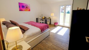A bedroom with a bed, bedside lamps, a desk, and a chair. - Modern and Cosy 5 Rooms Penthouse With Stunning View (Triesenberg)