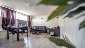 A modern living room with a dining table, two sofas, and a coffee table. - Bnb Central Apartment 4stavanger - Berti-2rooms (Stavanger)