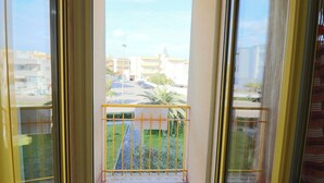 A balcony with a yellow railing, a view of a parking lot, and buildings in the background. - Casa Lucia Sea Breeze, Comfort and Relaxation by the Otranto Lighthouse (Otranto)