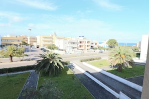 A residential area with buildings, a road, and palm trees.