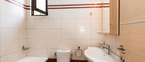 A bathroom with a bathtub, toilet, sink, and mirror.