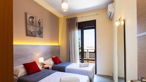 Een hotelkamer met twee bedden, een balkon en een groot raam.