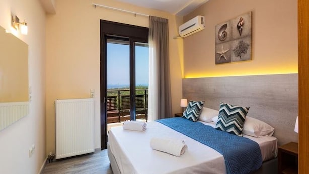Een hotelkamer met een groot bed, uitzicht, een airconditioning en een plafondlamp.