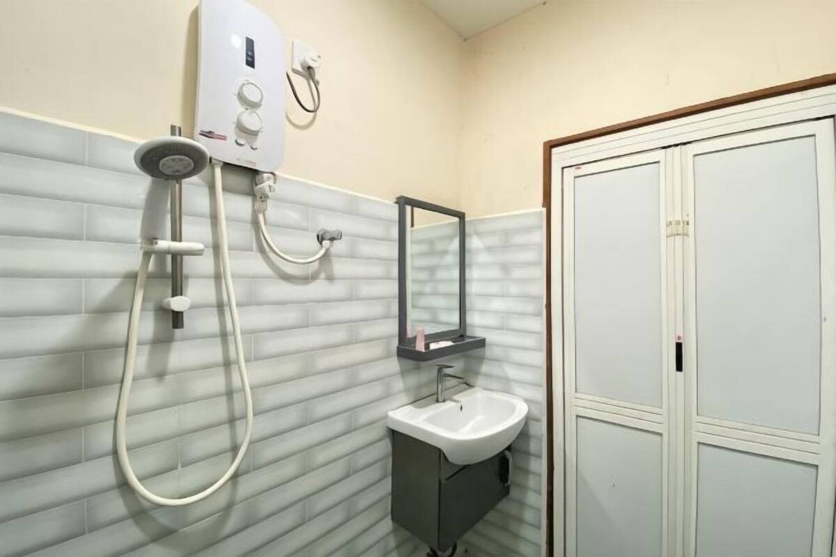 Un baño con ducha, lavabo y espejo.