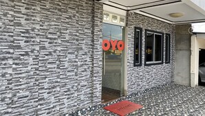 A building facade with a textured stone exterior and a tiled entrance. - Hotel O Bayu Sintok Motel (Changlun)
