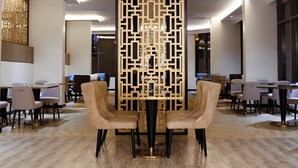 A modern hotel lobby with a central seating area featuring two beige chairs, a decorative wooden partition, and a polished wooden floor. - Iris Boutique Taif Heart (Taif)