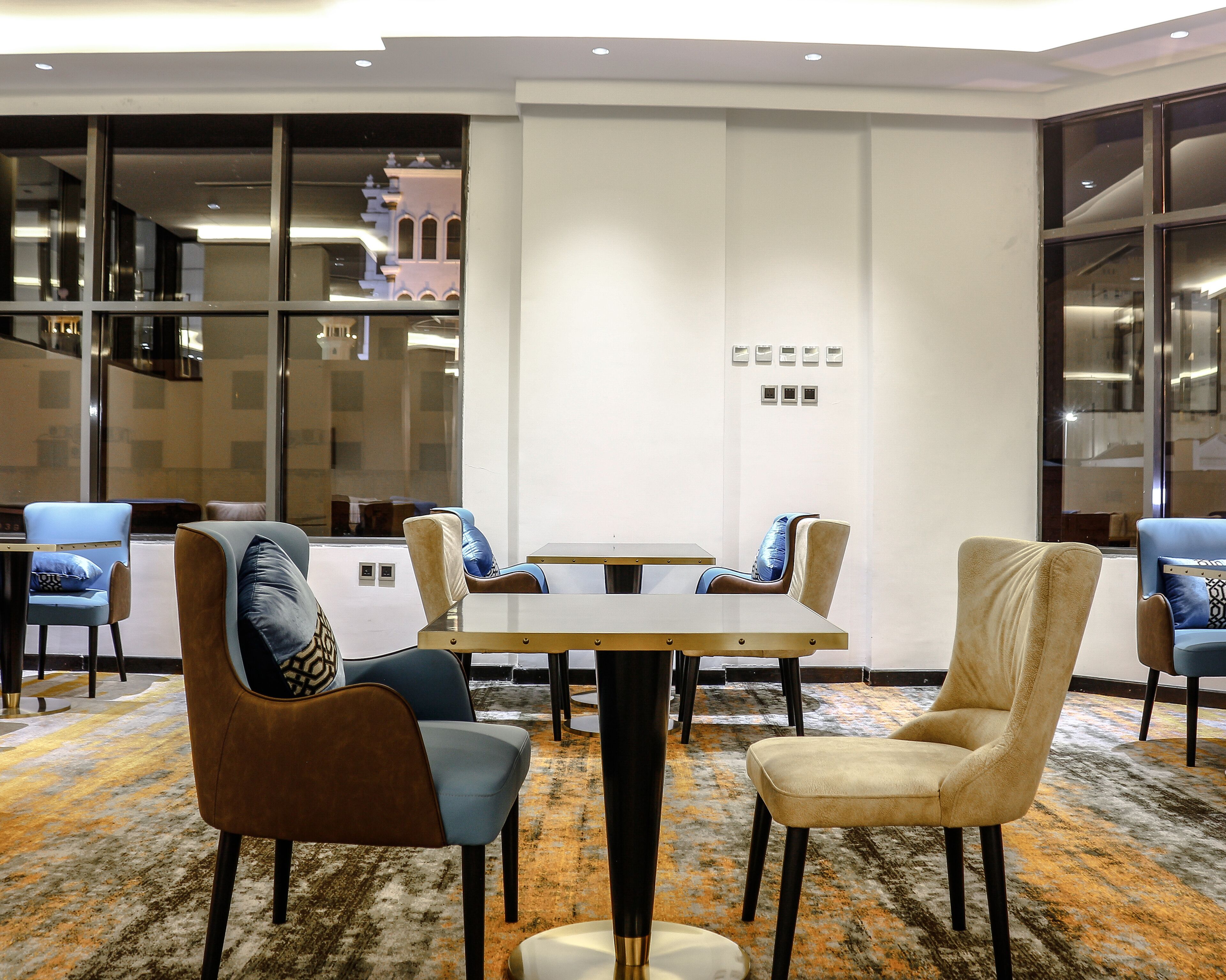 A conference room with a round table, six chairs, and a carpeted floor.