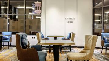 A conference room with a round table, six chairs, and a carpeted floor.