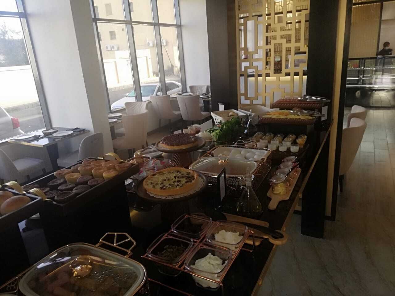 A buffet setup with various food items and a seating area with chairs.