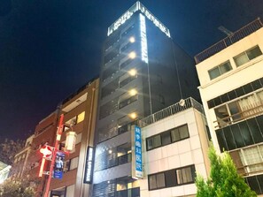 Un immeuble à plusieurs étages, avec une enseigne indiquant la présence d’un hôtel et d’un établissement médical.