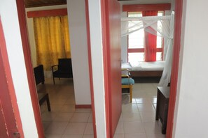 A room with a bed, a chair, and a desk. - Kogelo Suites (Kisumu)