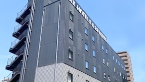A modern building with the sign "LIVEMAX HOTEL & RESORTS" on the top. It has multiple floors with balconies and a checkered pattern on the lower part. - HOTEL LiVEMAX Takamatsu Eki Mae (Takamatsu)