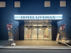 L’entrée de l’hôtel Livemax, avec une enseigne bien visible au-dessus des portes.
