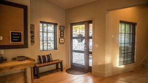 A wooden-floored hallway with a bench, a welcome sign, and framed pictures on the wall. - Gleneagles Golf Course Retreat with Hot Tub (Columbia Falls)