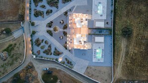 Luchtbeeld van een modern hotel met een centrale binnenplaats, meerdere kamers en een zwembad.