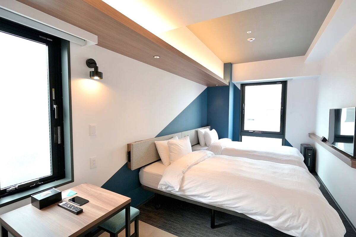 Ett modernt hotellrum med en säng, ett skrivbord och en TV.