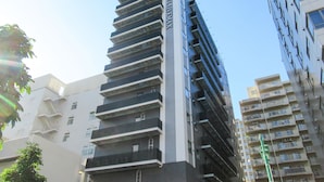 Un hôtel de grande hauteur doté de nombreux balcons et d’une enseigne indiquant qu’il fait partie de la chaîne LiveMax Hotels & Resorts.