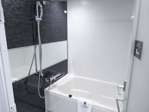 A modern bathroom with a bathtub, a shower, and a hand shower. - HOTEL LiVEMAX PREMIUM Nagoya Marunouchi (Nagoya)