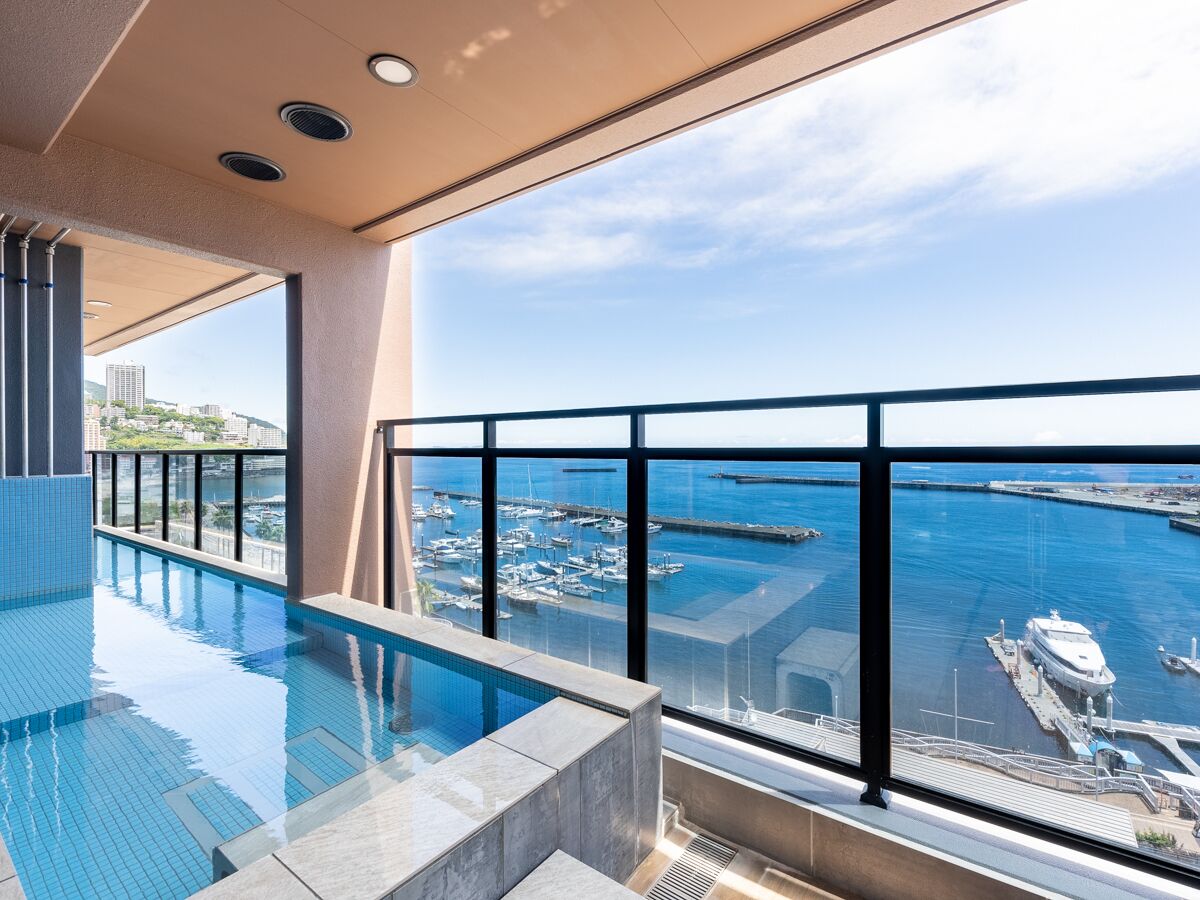 Une piscine intérieure moderne avec vue sur un port de plaisance et des bateaux.