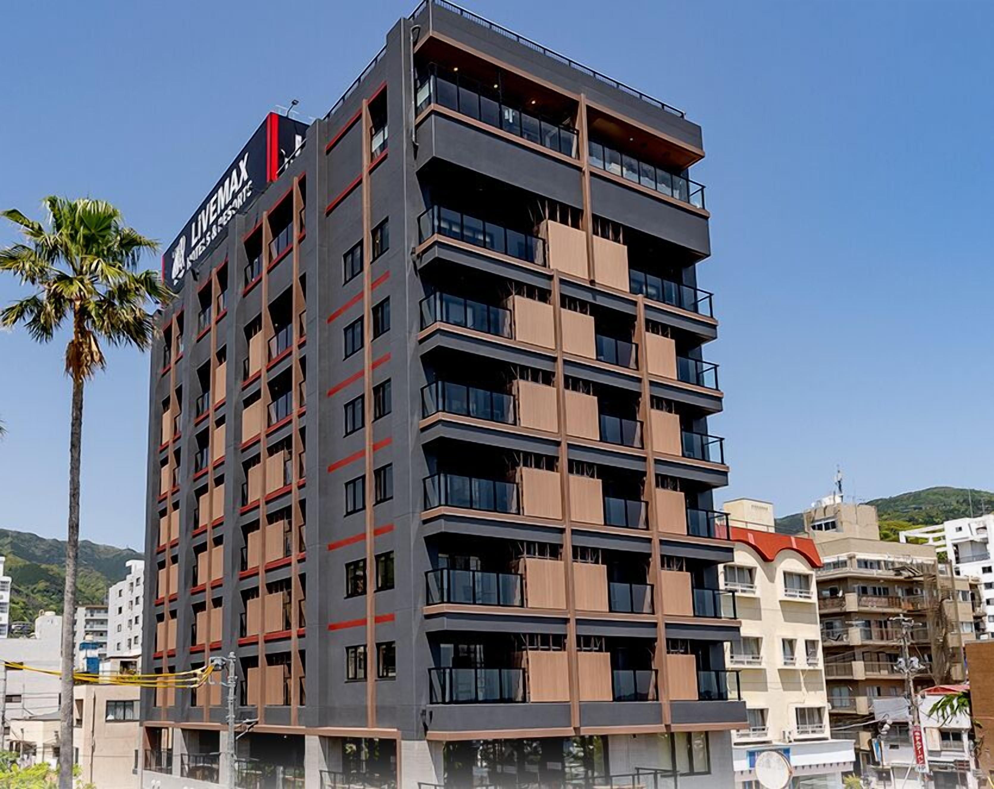 A multi-story hotel with a modern design, featuring balconies on each floor and a prominent sign at the top.