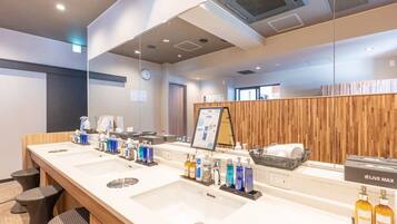 A modern bathroom with multiple sinks, a mirror, and a wooden wall panel.