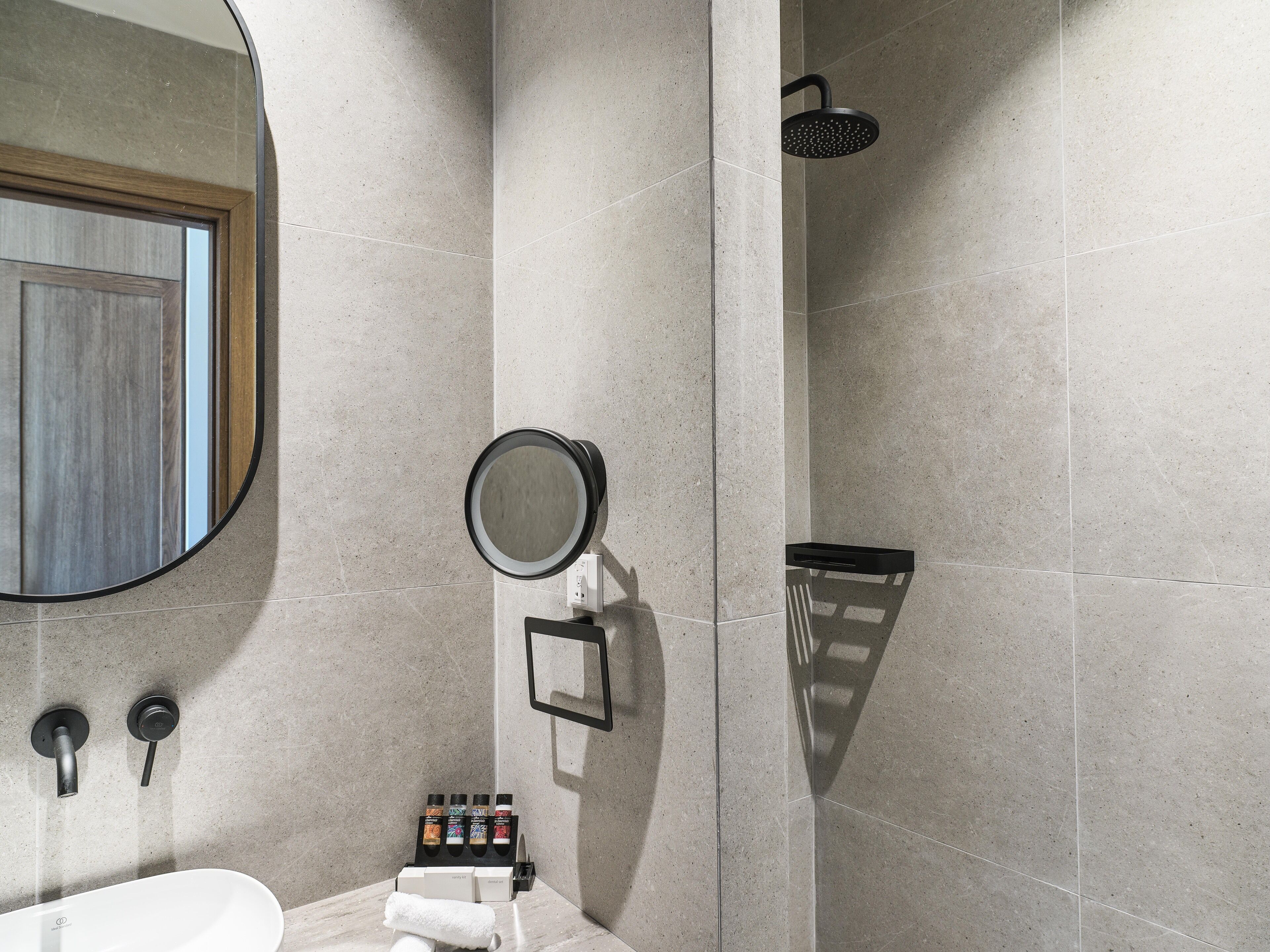 A modern bathroom with a shower, a sink, and a mirror.
